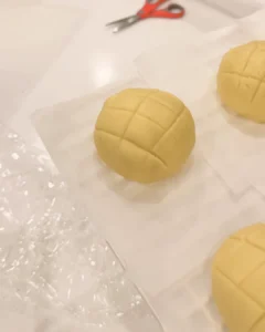 壓好菱形格紋的菠蘿麵包麵團排在烘焙紙上